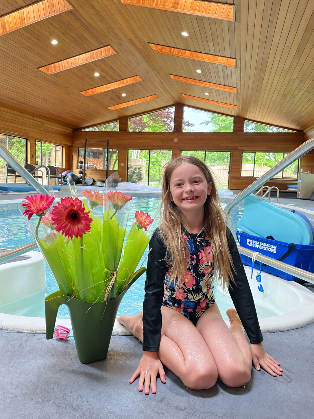 A young swimmer beside a wood-lined indoor pool, from Aquanauts’ Nanaimo location photos